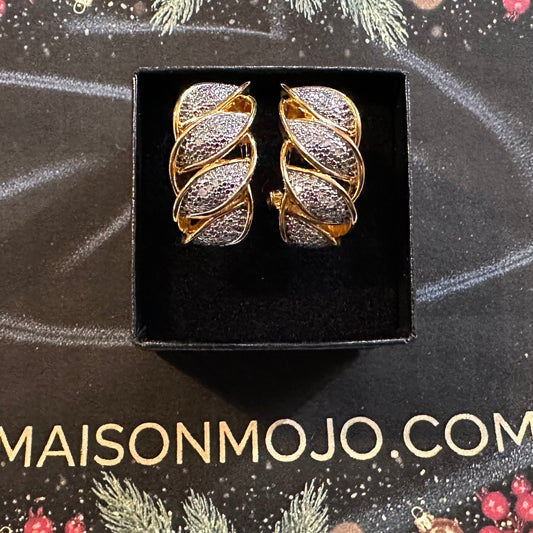 Pair of gold and silver earrings in a black box on a decorative background with 'MAISONMOJO.COM' text.
