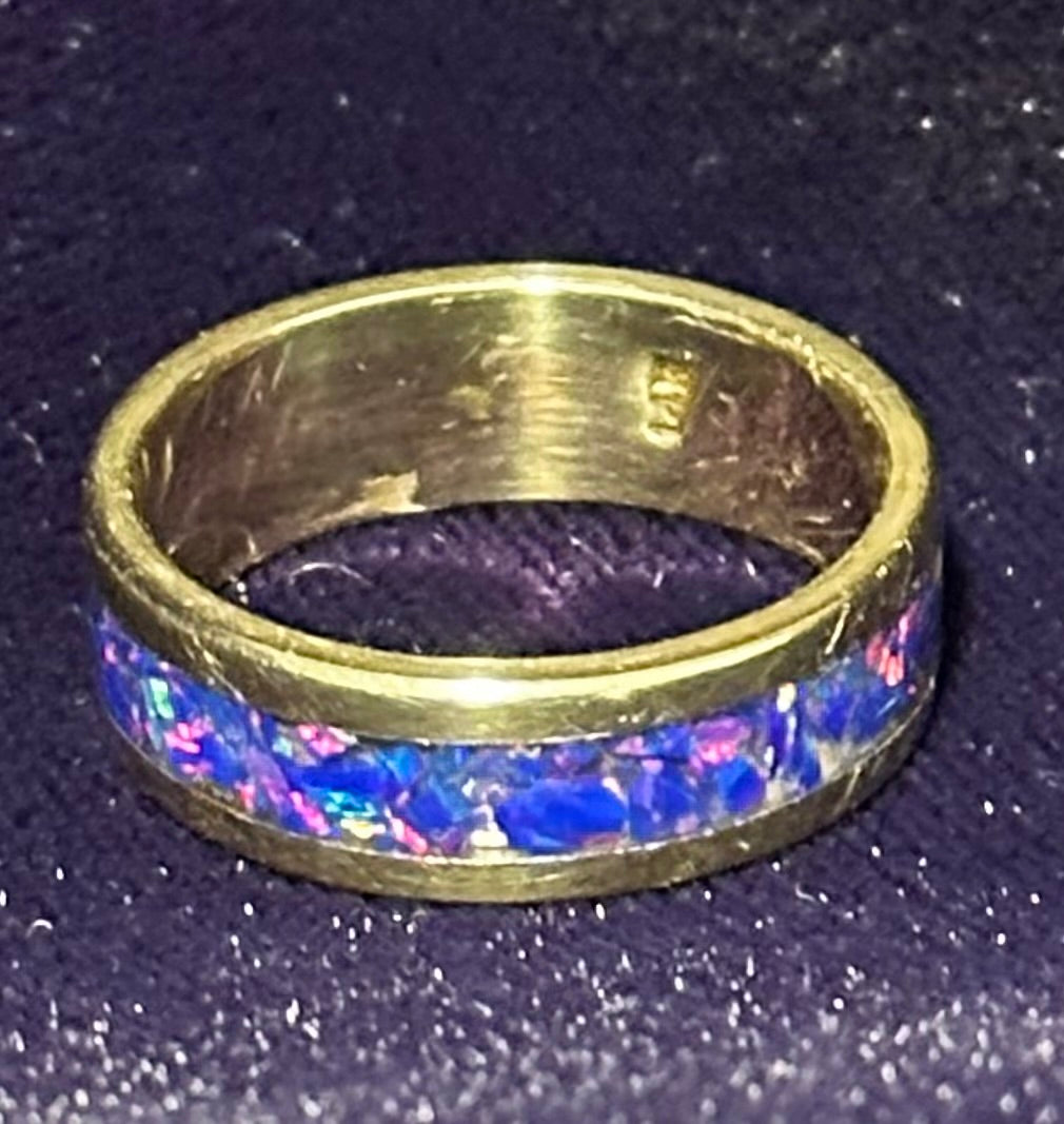 Close-up of hand-channeled electric blue fire opal inlay set in a 5.8g solid 14K yellow gold band.