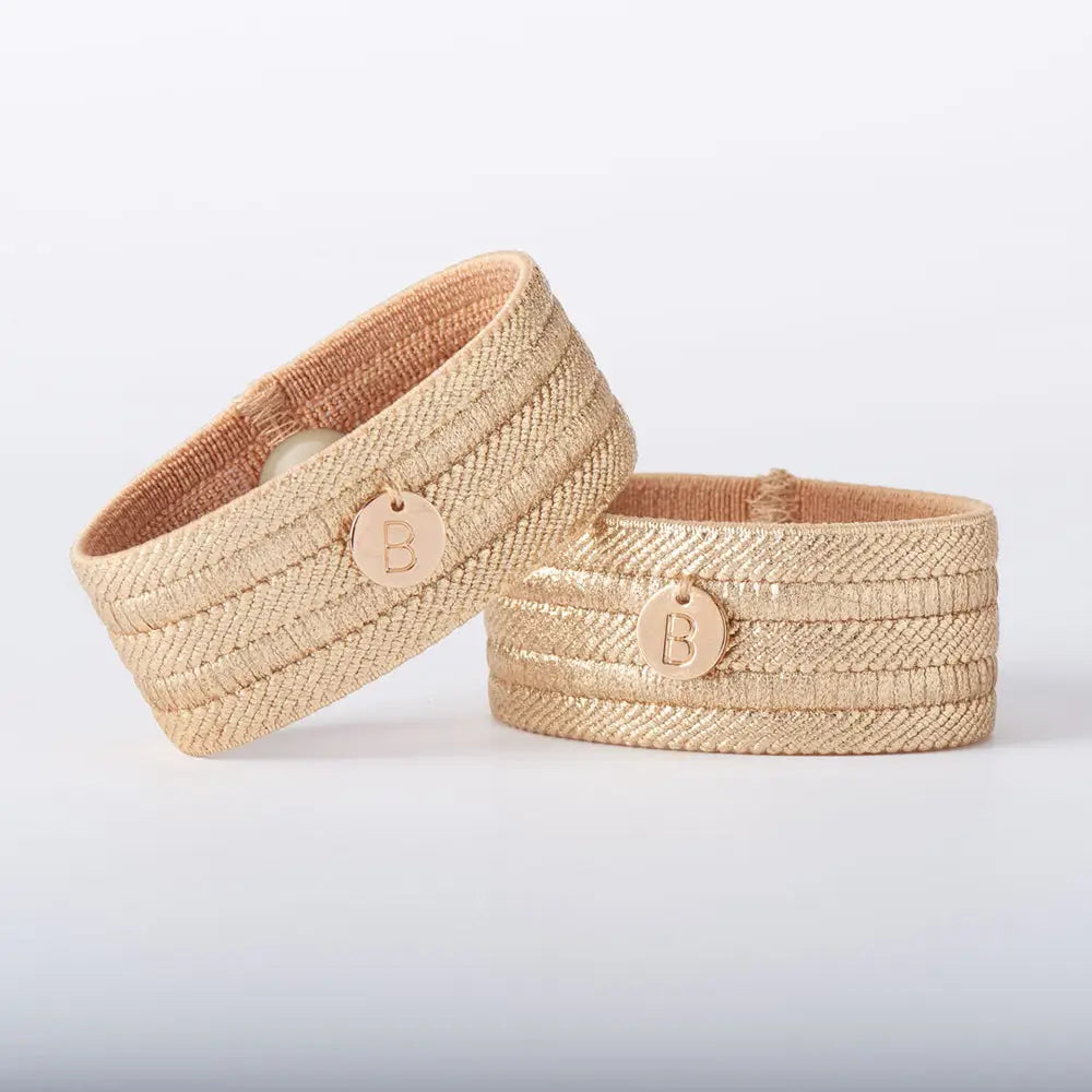 Two woven Blisslets Sofia Duo Nausea & Anxiety Relief Bracelets with a logo on a light gray background