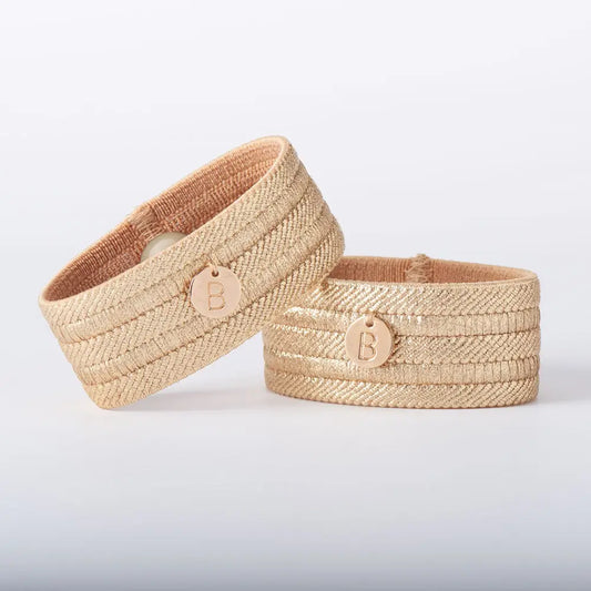Two woven Blisslets Sofia Duo Nausea & Anxiety Relief Bracelets with a logo on a light gray background