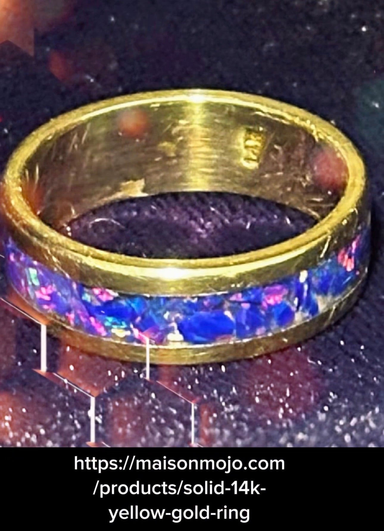 Gold ring with blue opal inlay on a dark textured background