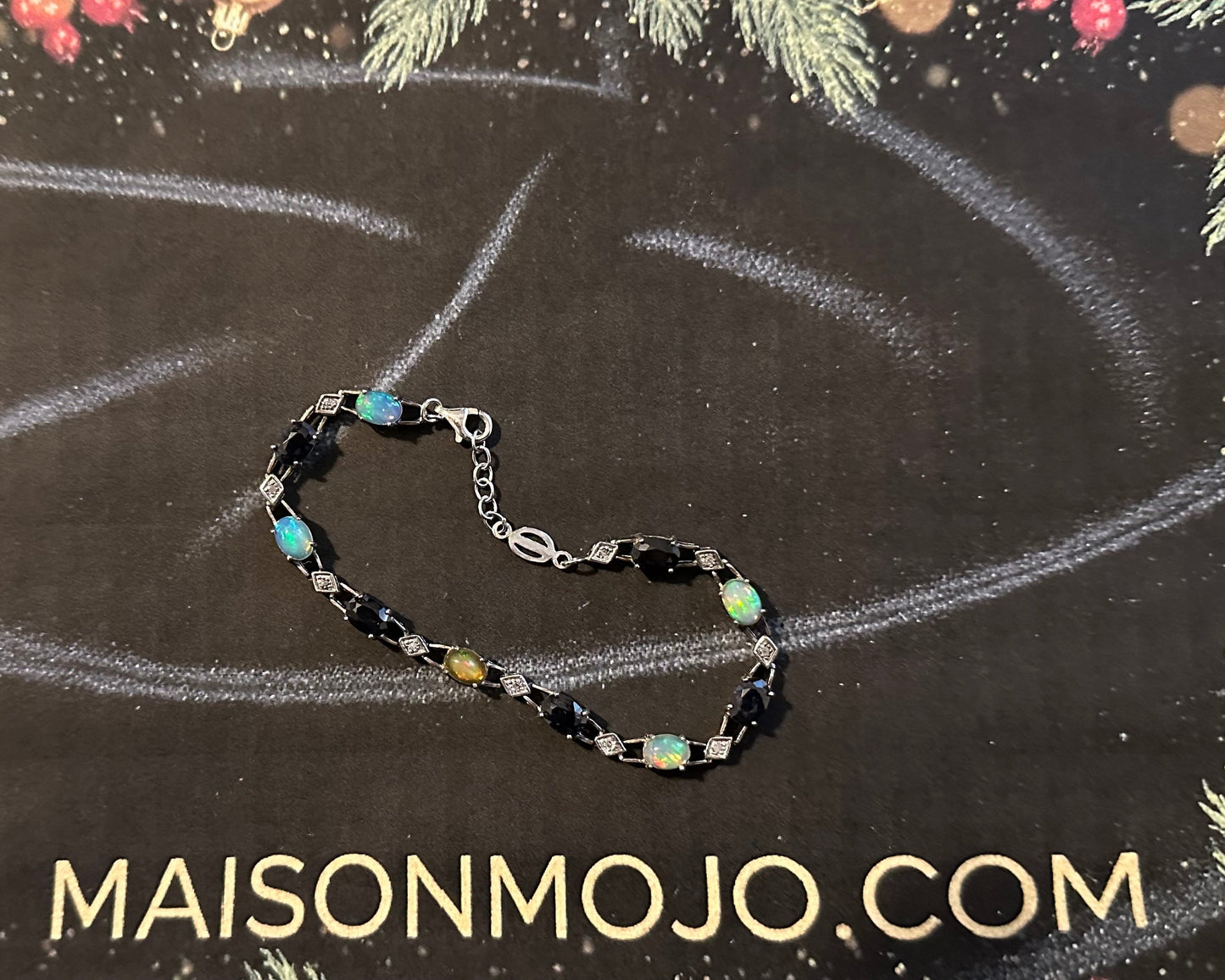 Bracelet with multicolored stones on a black background with 'MAISONMOJO.COM' text