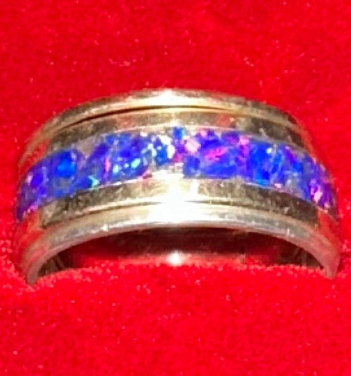 Three artisan rings stacked together including a solid 14K gold blue opal band with gold and silver stacking rings.