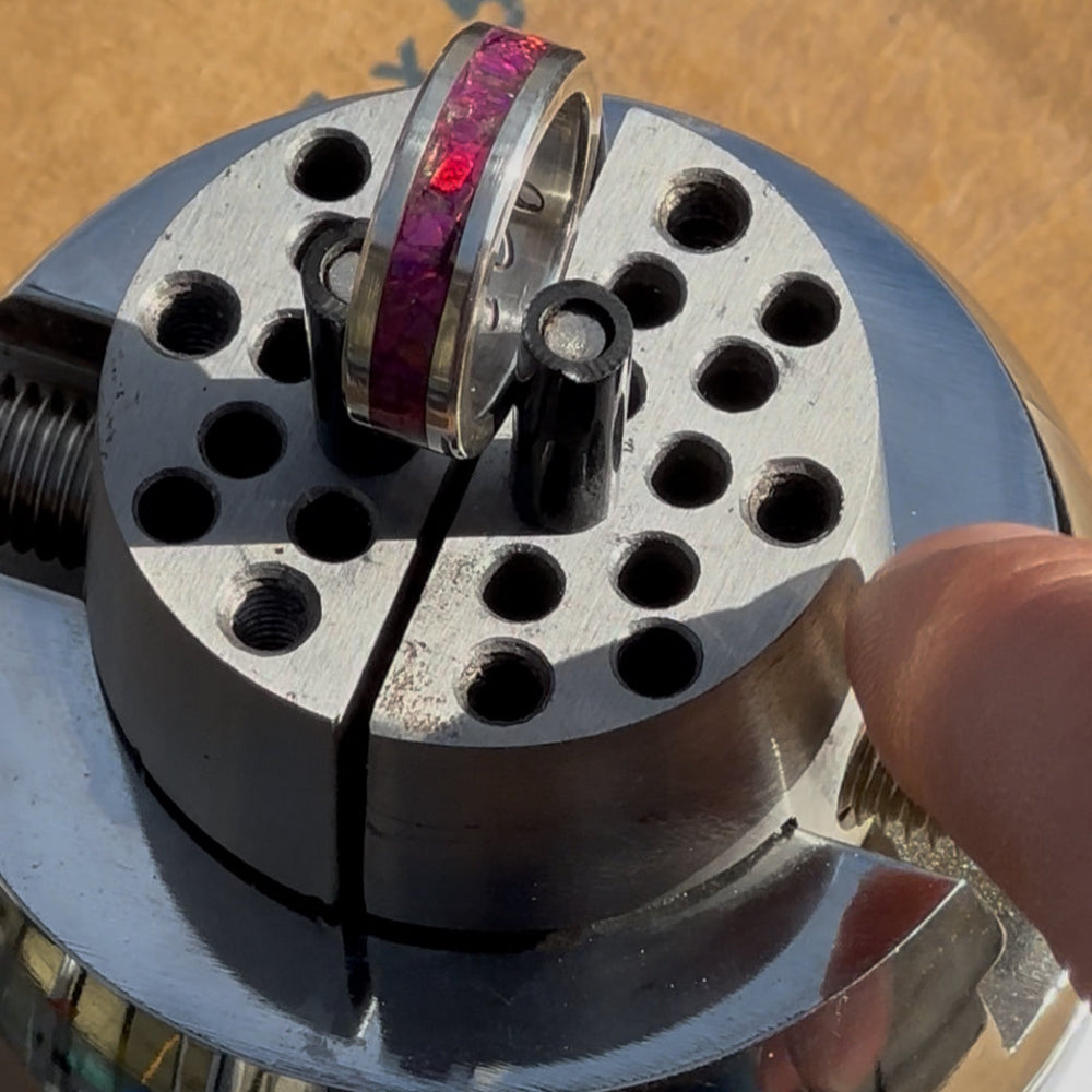 Close-up of a metal ball vice with a silver ring with pink Opal inlay