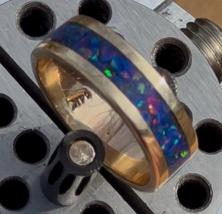 Close-up of hand-channeled electric blue fire opal inlay set in a 5.8g solid 14K yellow gold band.