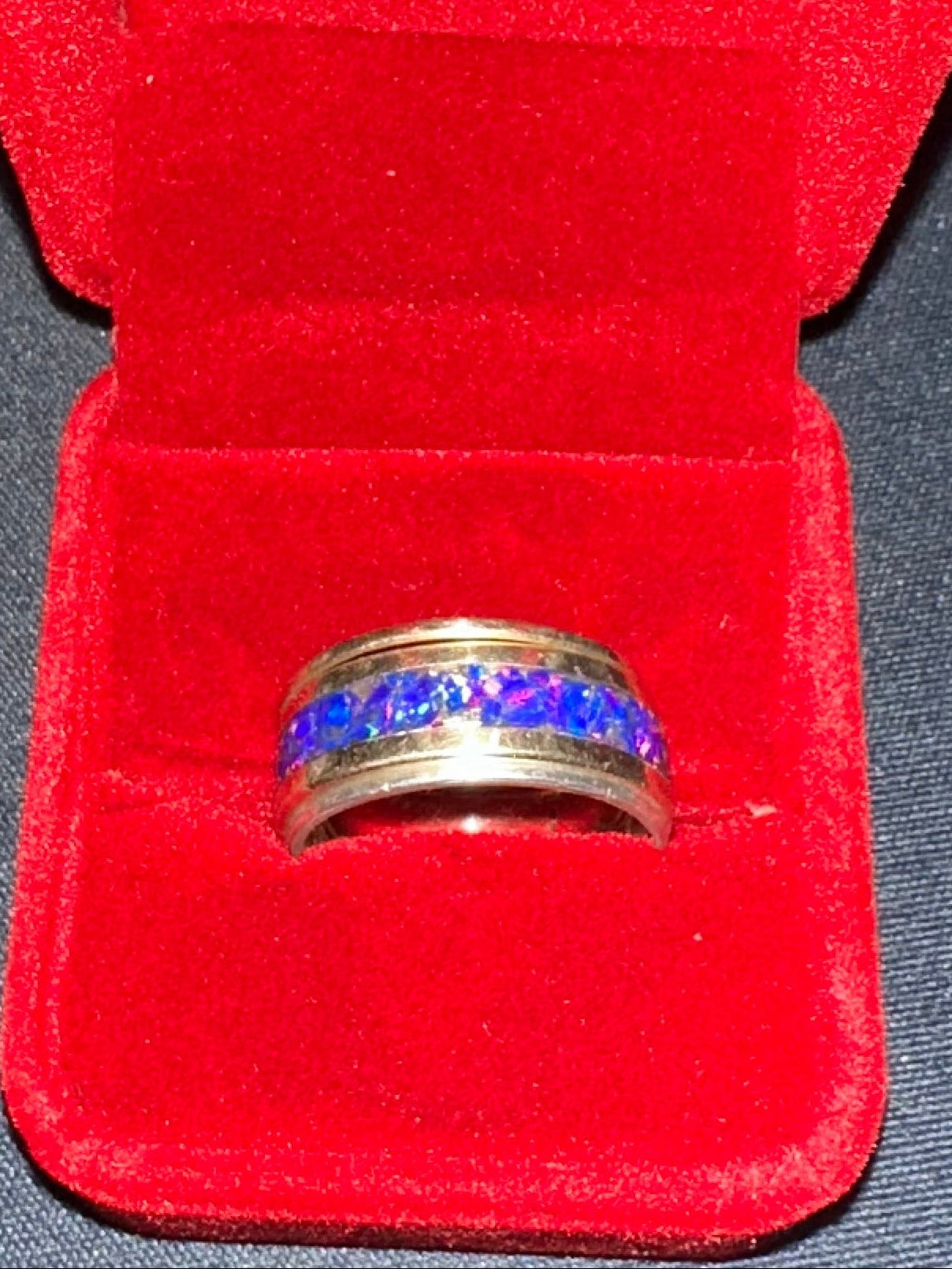 Three artisan rings stacked together including a solid 14K gold blue opal band with gold and silver stacking rings.