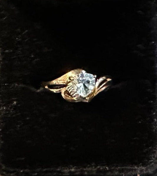Gold ring 1.0 CTW Swiss Blue Topaz (Trillion Cut) diamond in a black velvet ring box on a glittery surface with 'MAISONMOJO.COM' branding.
