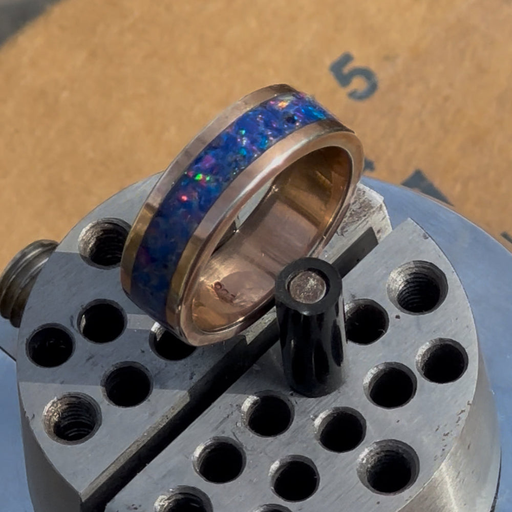 Ring with blue opal inlay on a metal anvil