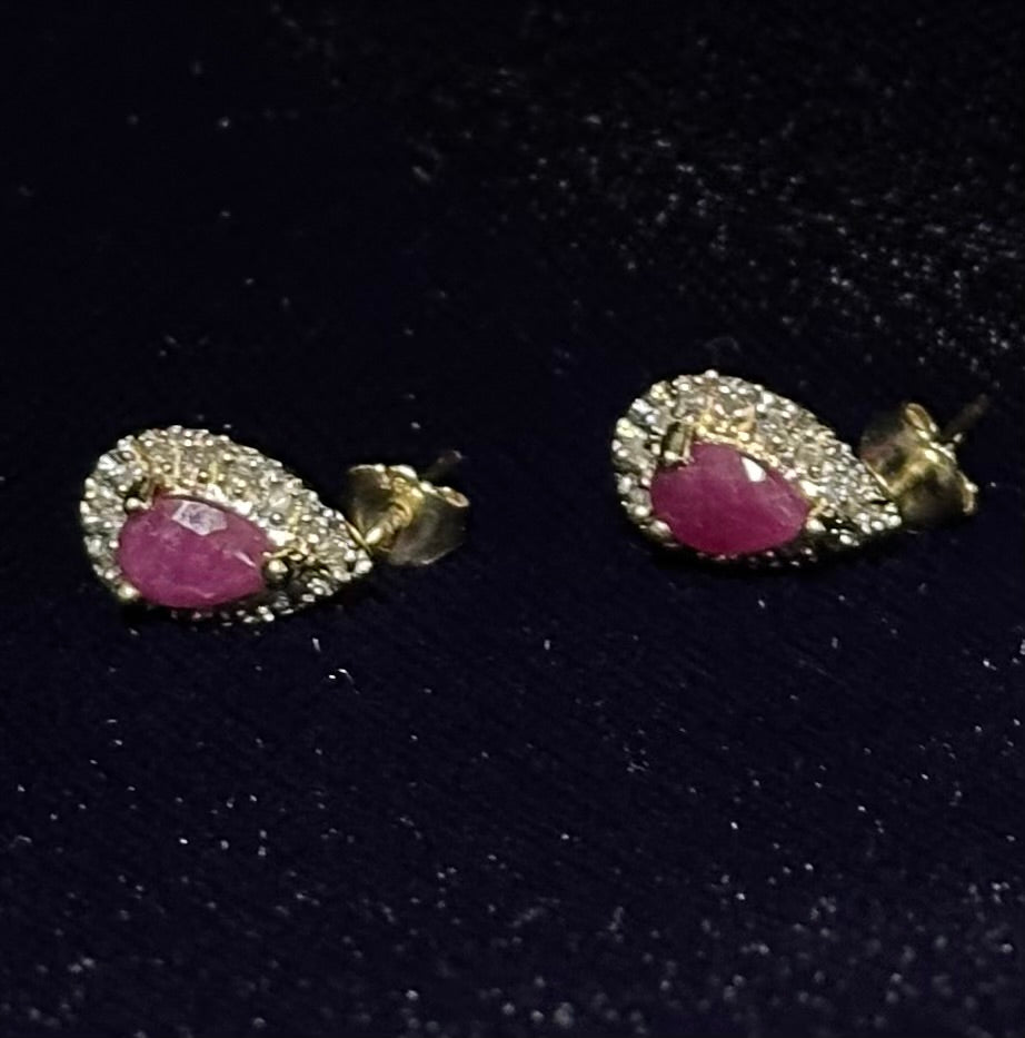 Pair of earrings with pink gemstones on a dark background