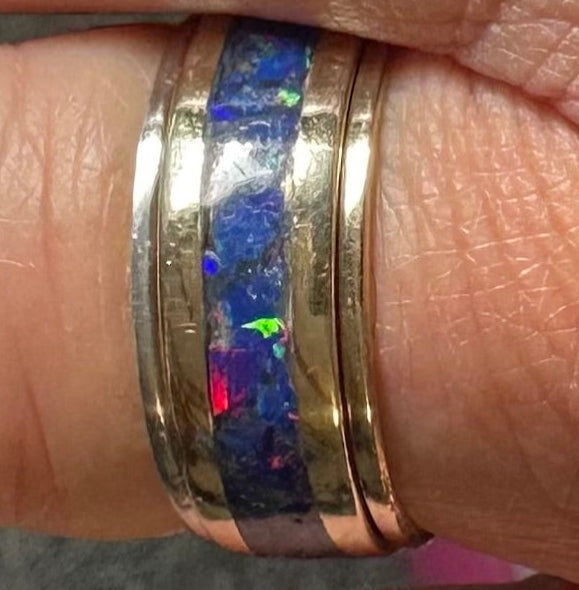 Two rings 1-14 karat gold 1-925 silver bling rings on a finger with a 14 karat gold blue Opal inlay  ring.