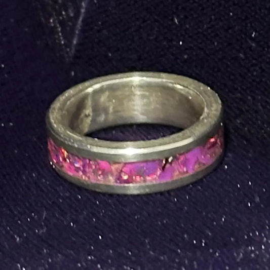 Silver ring with pink Opal inlay, on a dark textured background