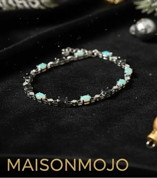 Bracelet on crushed black velvet with 'MAISONMOJO.COM' text, decorative elements around