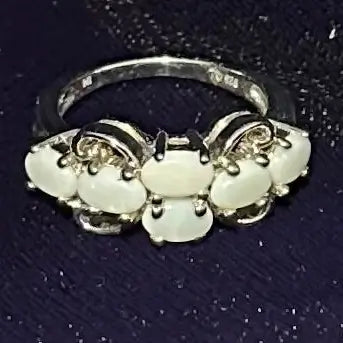 Silver ring with white Opal on a blue crushed velvet background